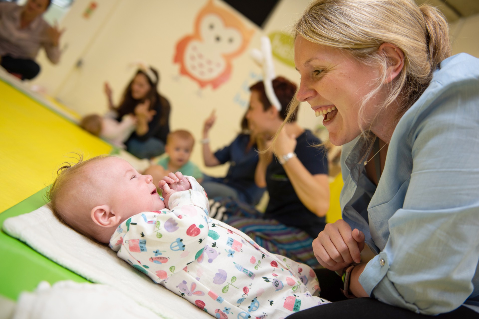 A Baby Sensory class leader sharing a joyful moment with a baby